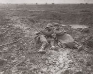 Un militaire canadien et un militaire allemand blessés s'allument une cigarette dans la boue de Passchendaele, Belgique en novembre 1917
