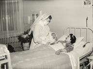 Une infirmière présente un nouveau-né à sa mère à l'Hôpital Sainte-Justine
