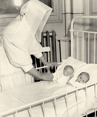 Religieuse gardant sous observation deux petites jumelles à l'Hôpital Sainte-Justine à Montréal