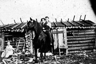 Athanase Bazinet et son épouse Mélina Plouffe au camp d'Emmanuel Hénault de Sainte-Émilie-de-l'Énergie. Madame Hénault est assise près du camp.