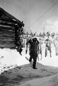 Le bûcheron Albert Dauphin étend son linge sur une corde au lac Catin