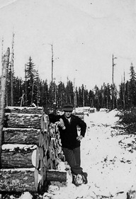 Le bûcheron Roger Beaudoin pose près de la corde de bois qu'il a fini d'étamper
