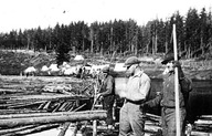 Campement de draveurs érigé sur le bord de la rivière