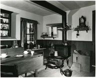 This was how the kitchen of a doctor’s home appeared more than 100 years ago. It has been recreated at Upper Canada Village in Ontario. Notice the “step-stove” wire holder on the chimney of the stove for holding the teapot and the old steeple clock above the woodbox.
